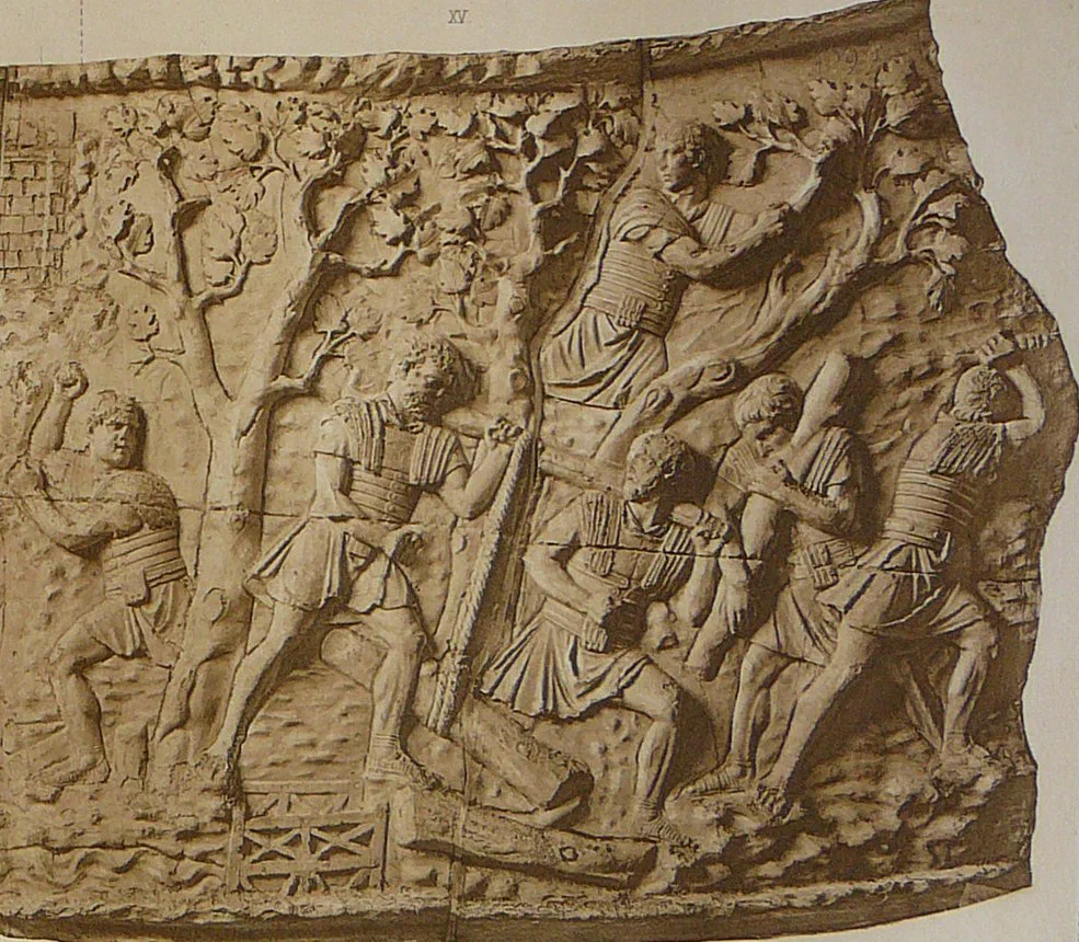 A carved frieze of Roman soldiers felling trees: one man up a trunk with an axe, others sawing and chopping, logs stacked below.