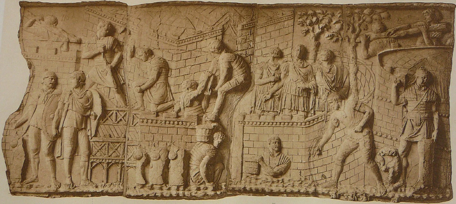 A carved frieze of Roman soldiers building fortifications: hauling baskets of earth, raising a wall, standing guard.